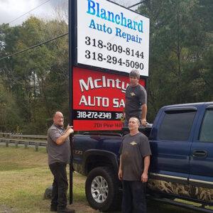 Installing Blanchard Auto Repair signage.